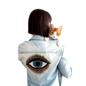 A Woman In A Denim Jacket Embroidered With An Eye Holding A Cute Cat Indoors. 19581 - Cat PNG image with transparent background
